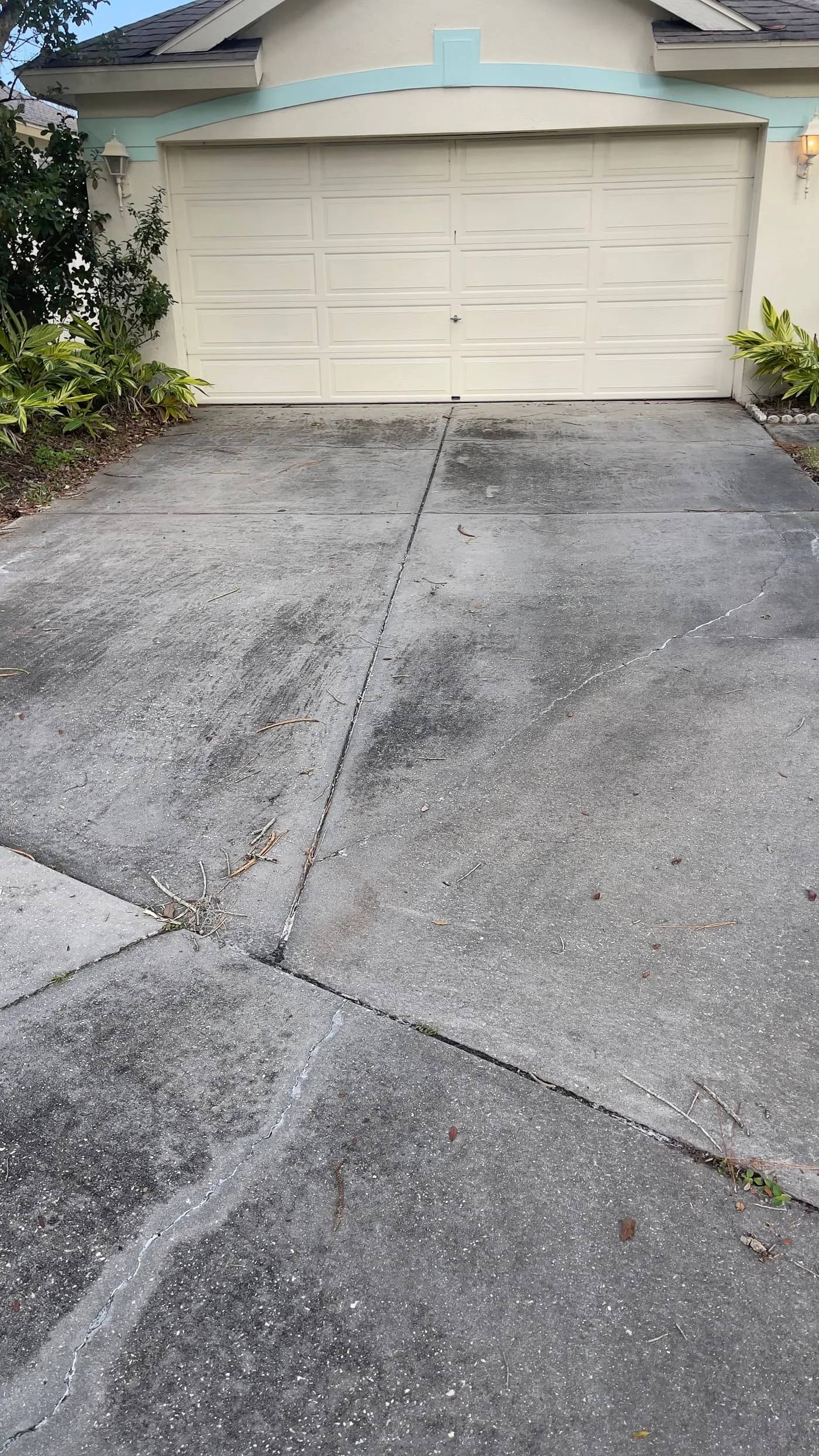 Before driveway cleaning in Tampa with surface buildup and darker weathering across the concrete