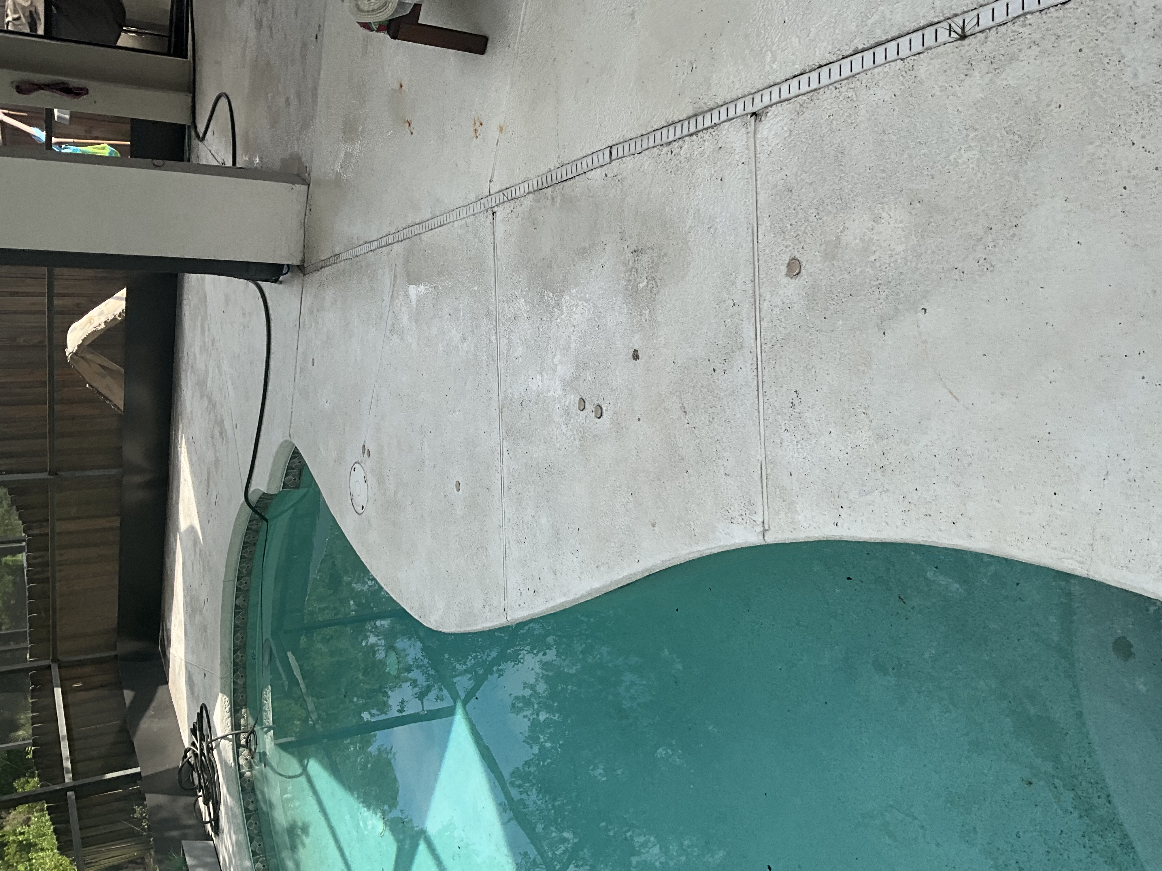 Pool deck cleaning in Tampa with a cleaner concrete surface beside a residential pool